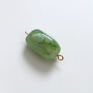 Close-up of a green marble resin square bead with a gold metal loop for DIY jewelry
