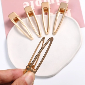 Detailed view of hollow teardrop gold hair clips showing a secure serrated grip design