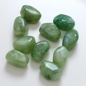 Irregular green marbled resin beads with ink-wash texture on white background