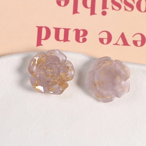 Vue macro de breloques roses en résine violette translucide avec des paillettes d'or