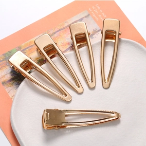 Five pieces of gold minimalist hollow teardrop hair clips on decorative ceramic plate