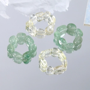 Detailed view of elastic natural stone rings with green aventurine and yellow crystal beads