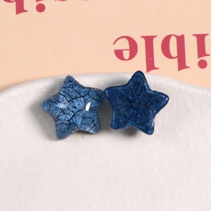 Macro detail of dark blue star resin accessories with crackle finish and glitter texture