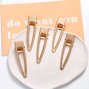 5-piece set of minimalist hollow gold geometric hair clips on a white ceramic plate