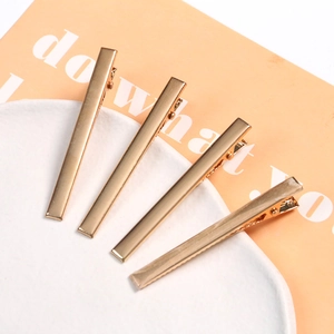 Set of four glossy gold metal duckbill hair clips for DIY hair styling and accessories