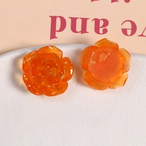 Détail de breloques roses en résine orange montrant le relief et la face plate pour DIY