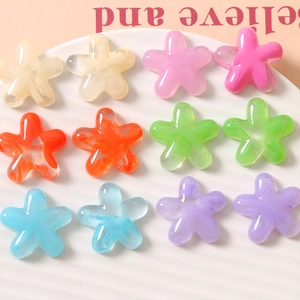 Flat lay of colorful semi-transparent resin flower charms with marble texture in a tray