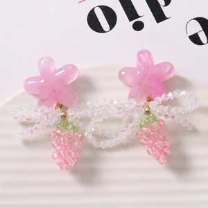 Pink resin flower earrings with beaded clusters on a minimalist white ceramic tray