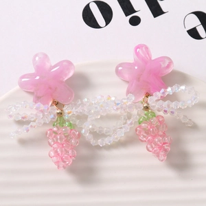 Detail of pink resin flower beads and clear crystal bow pendants for DIY jewelry making