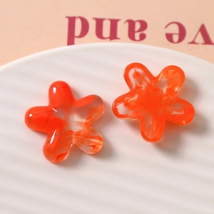 Detailed macro view of orange semi-transparent resin flower charms with marble texture