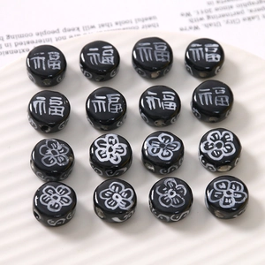Macro detail of black ceramic beads with white flower patterns and Chinese characters