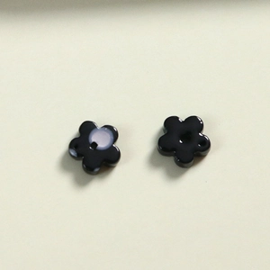 Primer plano de cuentas de resina negra en forma de flor brillante para joyería artesanal