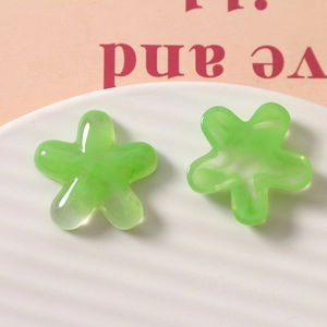 Macro view of green resin flower charms with marble texture for DIY jewelry making