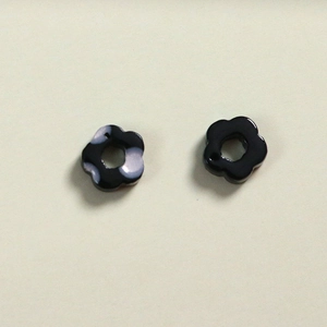 Detalle macro de colgantes de flores de resina para joyas DIY con agujeros de enhebrado