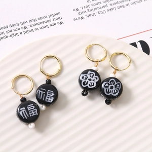 Detailed view of handmade neo-Chinese earrings with plum blossoms and Fu character beads