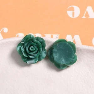 Macro view of green marble-textured resin rose charms on a white ceramic plate
