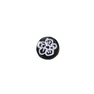 Flat round glass bead with hand-painted white plum blossom on a black background