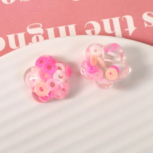 Close-up of transparent resin flower charms with colorful confetti for DIY jewelry making