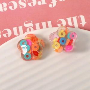 Detailed macro shot of transparent flower-shaped resin beads with colorful clay confetti