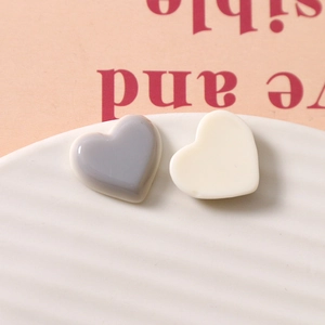 Detail von minimalistischen Harz-Herzanhängern in Grau und Creme für DIY-Schmuck