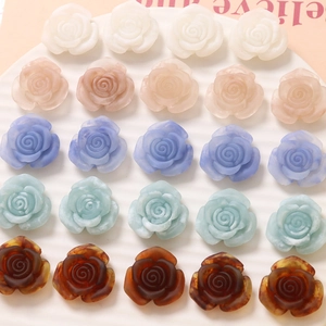 Flatback resin rose flower charms in pastel colors arranged in a white ceramic dish