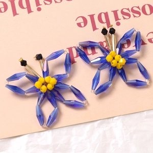 Macro shot of blue and yellow handmade beaded butterfly accessory on pink background