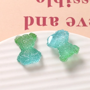 Detailed macro view of gradient blue and green gummy bear charms with frosted texture