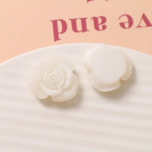 Macro view of white resin rose charms showing detailed petals for DIY jewelry making