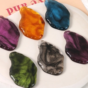 Retro ink-wash resin pendants in various colors displayed on a white round tray