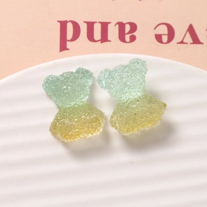 Macro shot of cute resin gummy bears with sugar coating and green yellow gradient finish