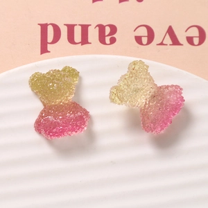 Macro shot of gradient glitter resin bear charms with sugar texture for DIY crafts