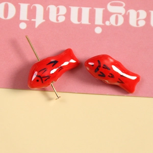 Makroansicht der roten Koi-Fisch-Keramikperlen mit goldenen Nadeln für DIY-Handschmuck