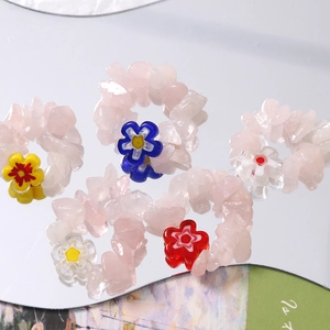 Detail view of five-piece pink quartz beaded rings with colorful floral glass beads