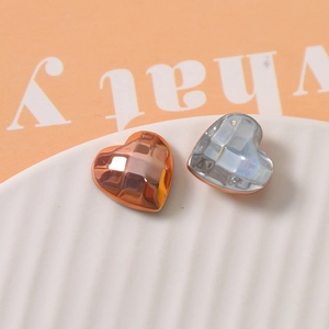 Macro shot of geometric faceted heart charms in metallic and pearlescent finishes