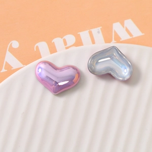 Close-up of heart-shaped pearlescent resin charms with iridescent pink and blue finish