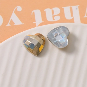 Detailed view of heart-shaped geometric faceted charms with gold and blue pearlescent textures