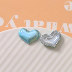 Close-up of heart-shaped pearlescent DIY charms in aurora blue and iridescent colors