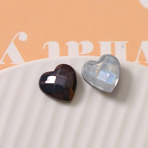 Detailed view of faceted heart-shaped resin charms in black and iridescent pearl white