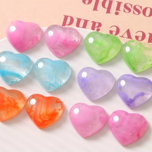 Translucent heart resin charms with colorful ink-wash pattern on a white plate