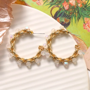 Orecchini a perno a forma di C in oro intrecciato con perle cangianti su vassoio bianco