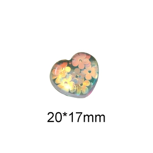 Macro detail of a 20x17mm heart-shaped resin accessory with translucent orange flowers