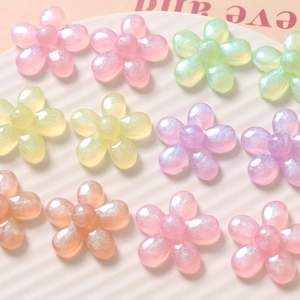 Détail de fleurs en résine translucide colorée avec paillettes fines sur un plateau blanc