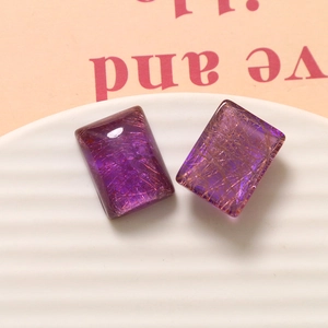Macro-opname van rechthoekige paarse hars cabochons met gouden zijden textuur op houder