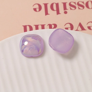 Macro detail of 18mm purple square resin charms with iridescent and matte finishes
