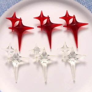 Close-up of sparkling resin star charms in red and clear tones on a white plate
