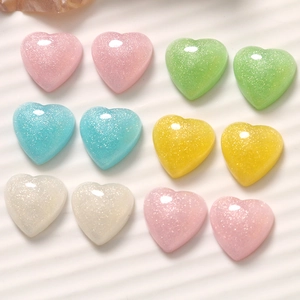 Macro shot of 16mm heart resin cabochons with glitter powder in pastel macaron colors