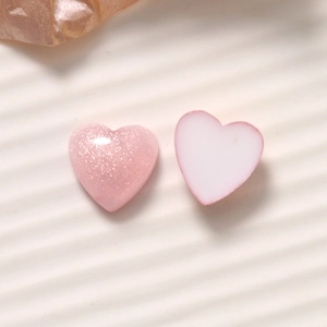 Close-up of glitter pink and matte white 16mm heart resin charms for DIY jewelry making