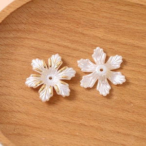 Gros plan de perles en forme de fleur avec bordure dorée pour bijoux artisanaux