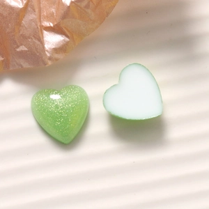 Detail of 16mm glittery green and creamy white heart resin charms for DIY craft accessories