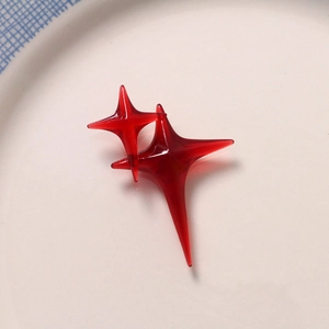 Macro detail of red translucent resin four-point stars for DIY jewelry and hair accessories